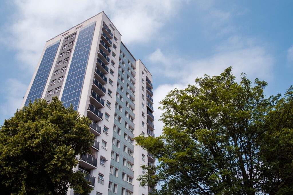 Tall block of flats, trees and blue sky